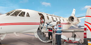 AMREF Flying Doctors medical personel board a patient onto a plane. 