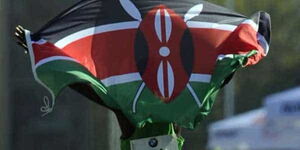 An athlete celebrates with a Kenyan flag after winning a race