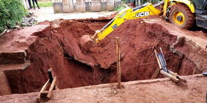 An excavator digs out earth from a construction site that caved-in.