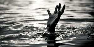 An image of a hand of a drowning child emerging from the water.