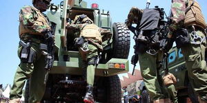 A file image of police officers hoping into an Armoured vehicle