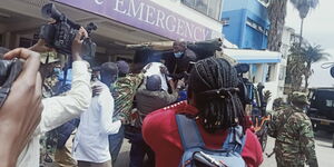 Journalists and police officers pictured at the entrance of the Kenyatta National Hospital on August 25, 2021.