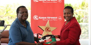 COTU Secretary General, Francis Atwoli(Left) and the KQ Chief Human Resources Officer, Evelyne Munyoki(Right) receiving the reward on Tuesday, October 12, 2021.