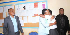 Murang'a County Woman Representative, Betty Maina (centre) hugs Fidelis Wangari, a Form Two student at Kahithe secondary School, Kiharu Constituency, Murang'a County, on October 26, 2022.