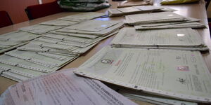 A file image of Kenya National Examination Council certificates on a table.