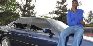 An undated photo of former soccer star Boniface Ambani seated on top of a car's bonnet.