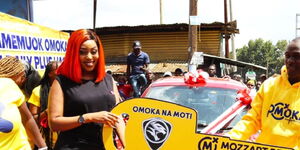 Social Media Influencer Amber Ray awards carpenter Simon Airo with his Omoka na Moti Promotion prize, a brand new Proton Saga.
