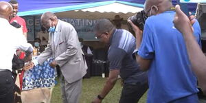 St Peters Mumias Boys High school Cassianus Ijait Aluku (center) receives gifts from the alumni.