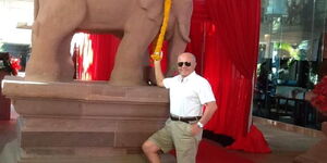 Kenyan-based investor of Italian origin,  Franco Esposito, posing for a photo while holding an elephant sculpture. 
