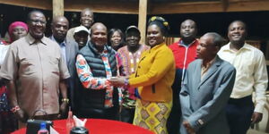 Jackline Okanya Malala (yellow) shakes hands with Kakamega Gubernatorial candidate, Fernandes Barasa.