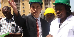 Erdemann Property managing director John Yang (left) shows building plan to the then Cabinet Secretary for Land, Housing and Urban Development Charity Ngilu during the groundbreaking ceremony for a ksh1 billion Great Wall Phase Two 384 three-bedroom apartments at Mlolongo area in Nairobi in October 2013.