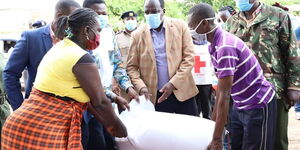 Governor Oparanya (centre) hands out a bag of rice to a resident of Navakholo, Kakamega County on May 9, 2020.