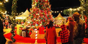 A family surrounding a Christmas tree during the festivities.