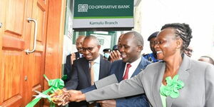 Co-op Bank Director Retail & Business Banking William Ndumia assisted by Mr. Samuel Mukiti; Relationship Manager, Government Banking and Ms. Linda Mango; Regional Manager cut the ribbon during the official opening of Co-op Bank Kamulu branch