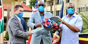 Director of Criminal Investigations (right) receives a donation from US Ambassador Kyle McCarter on Friday, May 29, 2020