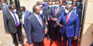 President Uhuru Kenyatta and his deputy William Ruto converse at the National Prayer Breakfast on Thursday, May 27.