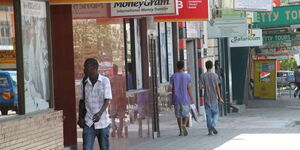 Passers-by walk past a Diamond Trust Bank branch