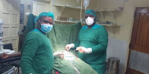 Dr Benjamin Magare Gikenyi and a colleague during a surgical procedure.