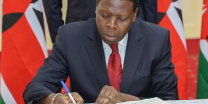 Devolution Cabinet Secretary Eugene Wamalwa signing the deed of transfer on Tuesday, February 25, at State House, Nairobi
