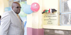 Former Education CS George Magoha poses next to a CBC classroom he commissioned at the Rev. Gitau Secondary School on Sunday, July 31, 2022.