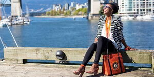 Entrepreneur Jackee Kasandy, with a sample of her bag collection posing for a photo