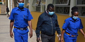 Karen Ward MCA David Mberia escorted by police officers to court on Thursday, February 25.