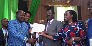 IEBC chairman Wafula Chebukati (left) presents the clearance papers to Azimio la Umoja presidential candidate Raila Odinga (centre) and his running mate, Martha Karua.