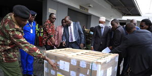 Former IEBC chairman Wafula Chebukati (centre) receives the first batch of ballot papers at JKIA on July 7, 2022.