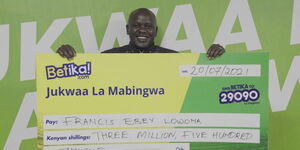 Francis Ebey Lowona, one of the five midweek Jackpot winners displays a Ksh3.5 million cheque.