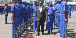 Interior Cabinet Secretary Fred Matiang'i inspects a guard of honour during a passing out parade for 1,224 officers in December 2019