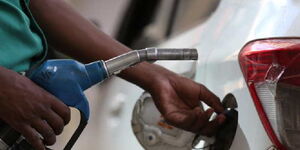 File image of fuel attendant fueling a car