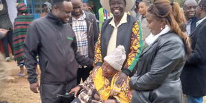 Rigathi Gachagua helping an elderly woman at Sagana Primary School in Nyeri County on August 9, 2022.