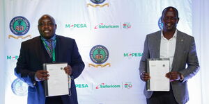 HELB CEO Charles Ringera (left) and Safaricom Chief Financial Services Officer, Sitoyo Lopokoiyit (right) pose for a photo while holding the MOU signed between M-Pesa and HELB during the official launch of M-Pesa HELB partnership on March 2, 2021