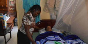 Magdalene Muthoni (left) attends to Hannah Wanjiku at her home in Harambee Estate, Nairobi.
