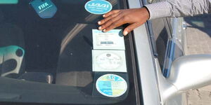 File photo of a motorist checking insurance sticker on his car
