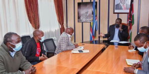 Interior CS Fred Matiangi (on phone) during a meeting with Kamukunji Business Community on Monday, August 16, 2021.