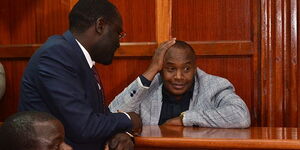 Starehe MP Charles Njagua has a chat with his lawyer at the Milimani Law Courts on June 28, 2019