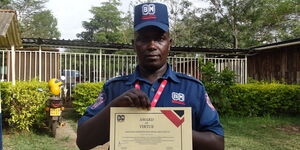 Security Guard Joseph Mugendi poses with a certificate after being awarded on March 17, 2020
