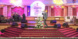 A pastor on a podium inside Jubilee Christian Church Managed by Kathy Kiuna and her Husband Allan Kiuna.