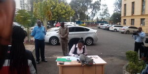 A judge hears a case outdoors at the Milimani Law Courts in Nairobi on Tuesday, March 17, 2020