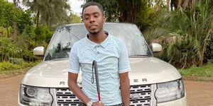 Julius Mbura posing in front of a Range Rover Vogue