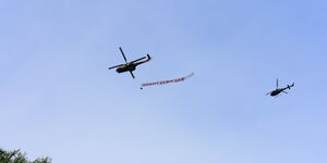 A military chopper with a banner written 'God bless medics' flies over Nairobi on Tuesday, April 21, 2020