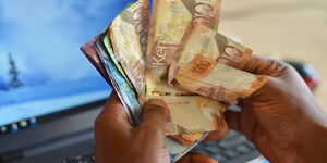 An image of a man holding a stash of cash