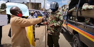 A protester confronts a police officer during anti-corruption protests in Kabarnet on August 25, 2020