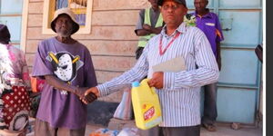 Ambrose Safari a community social worker of Mwangaza initiative distributing food to the vulnerable on Monday, October 2022