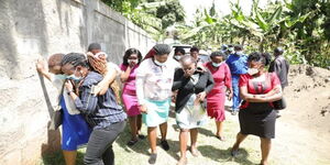 Relatives and residents of Karura village grief outside the home of a Kiambu family that was murdered