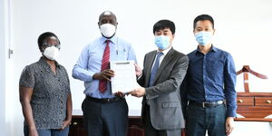 KeNHA Director General Peter Mundinia (second left) holds the signed tender award to China Communication Construction Company alongside the firm's officials