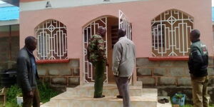 Kenya Police officers pictured outside a house designated as a crime scene.