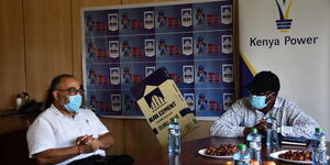 Kenya Power MD Bernard Ngugi and Rai Cement Ltd Group Finance Controller Rakesh Kumar hold a discussion during a tour of Rai Cement in Muhoroni town, Kisumu County