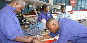 Kenyan workers at an airplane hangar.